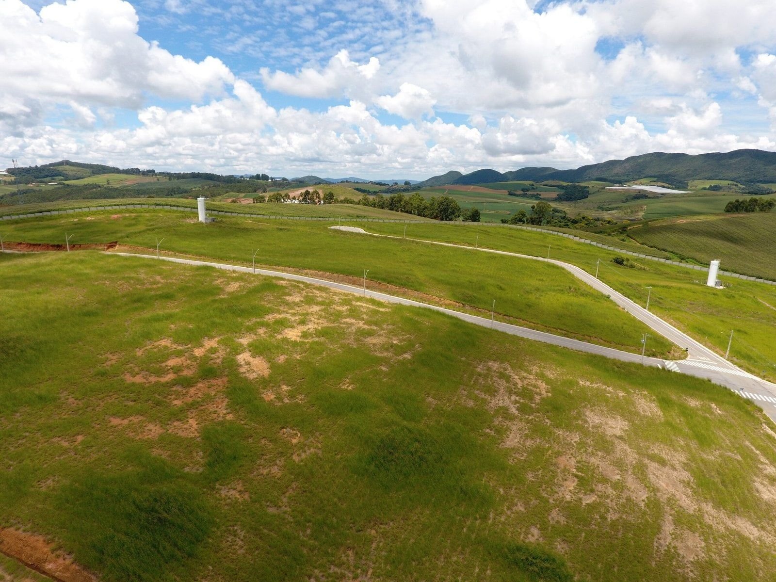 Área gramada e ruas do Quinta das Flores com a serra no horizonte