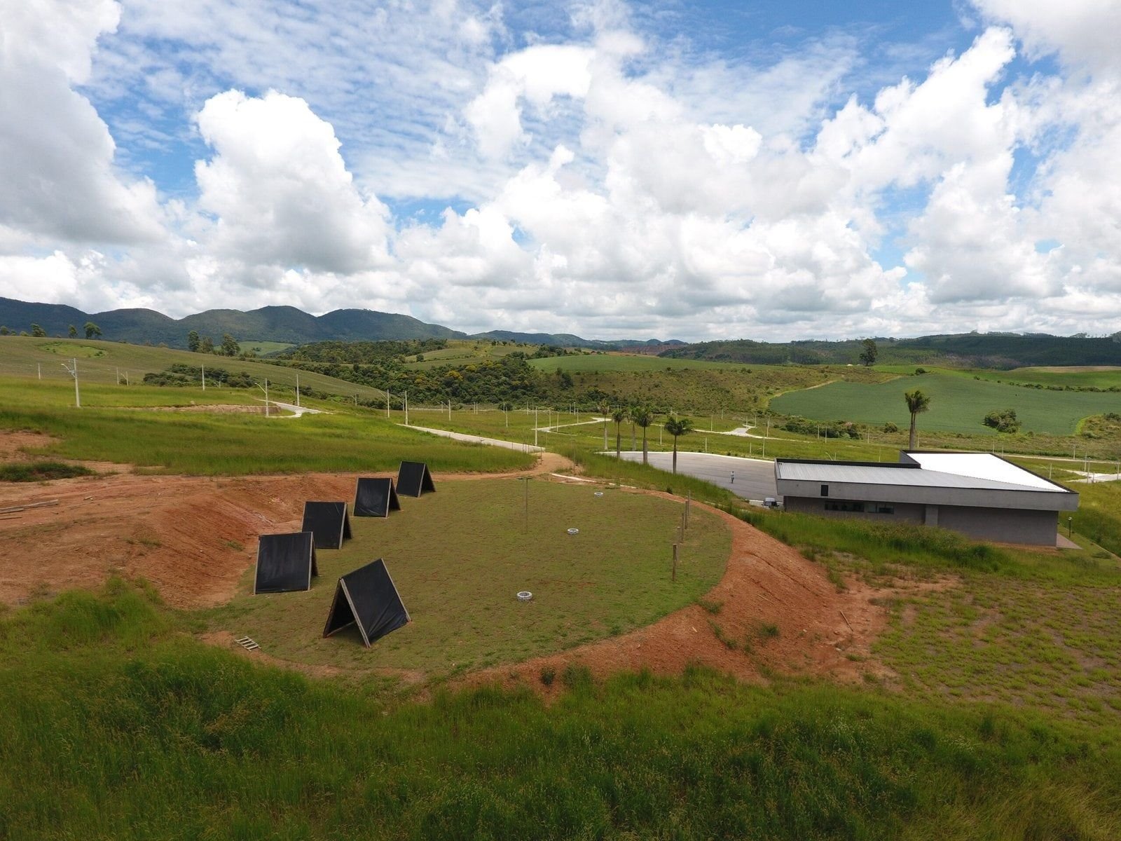 Área de lazer do Quinta das Flores entre colinas, com construção ao fundo