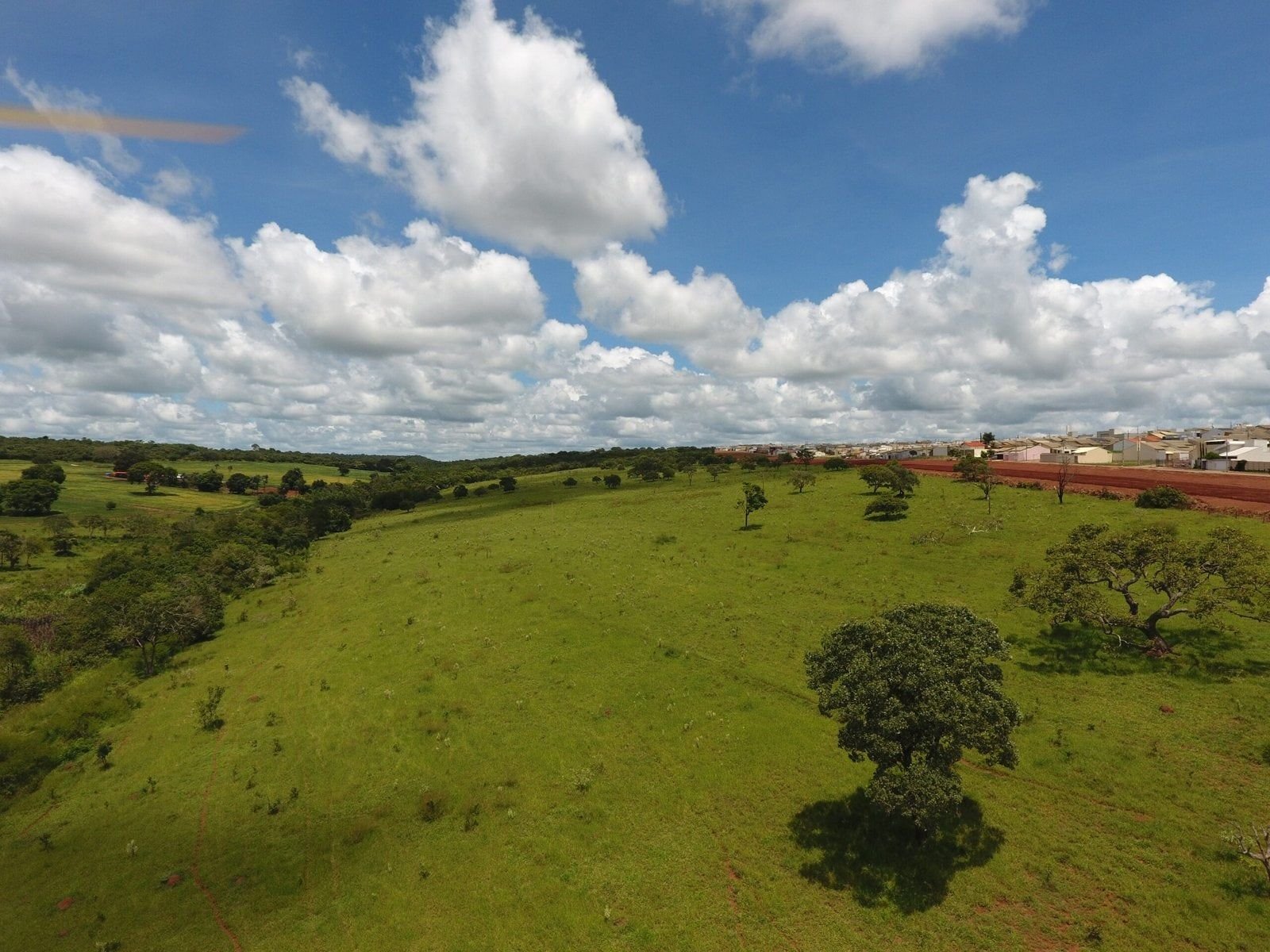 Área verde do empreendimento sob céu com nuvens